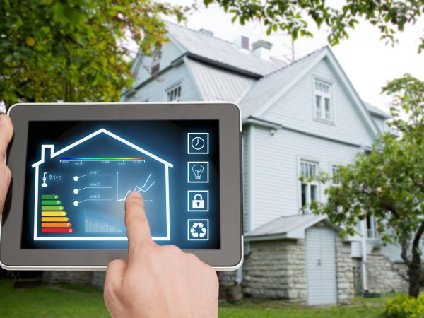 home, housing, people and technology concept - close up of man hands pointing finger to tablet pc computer and regulating room temperature over house background